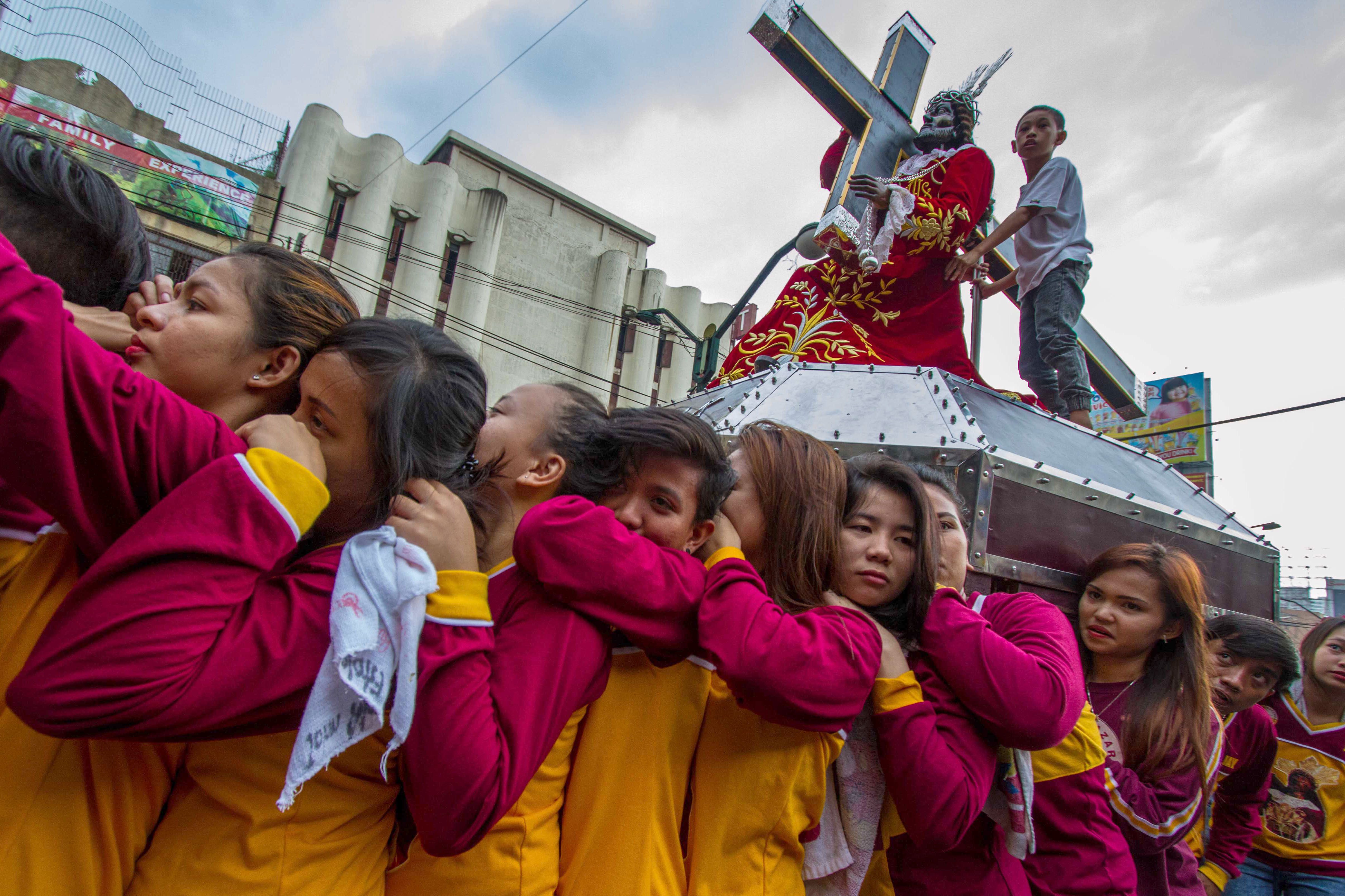 Renalyn Macarandang (3rd from left) together with a group of women carry a statue of the Black Nazarene on their shoulders during the procession of replicas. 