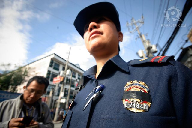 SCARRED. A black ribbon is tied over the badge of police officers of the QCPD as they mourn the death of the 44 SAF members on January 30. File photo by Ben Nabong/Rappler  