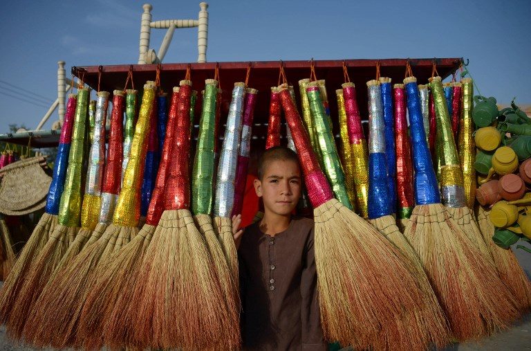 MAKING A LIVING. Afghan vendor Rafi, 9, poses for a photograph as he sell brooms at a roadside stall in Mazar-i-Sharif on May 30, 2018. Photo by Farshad Usyan/AFP  
