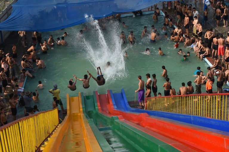 START OF SUMMER. Pakistani youth take a plunge through a water slide during a hot day in Lahore on May 27, 2018. Photo by Arif Ali/AFP  