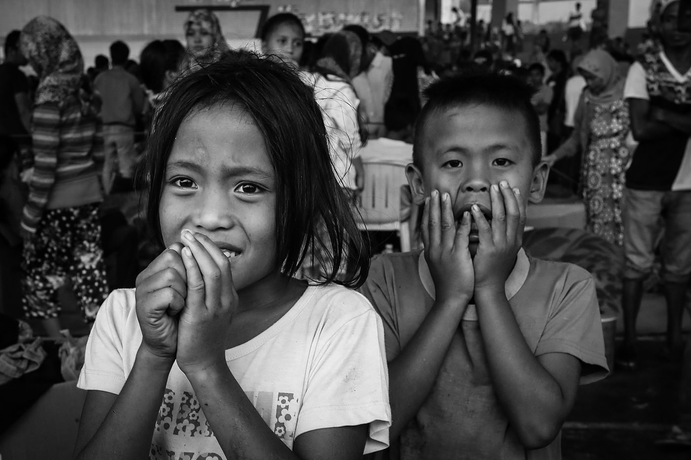 Visibly shaken, these children, who have just arrived with their families at Saguiaran evacuation camp, are welcomed by a thunderstorm. 