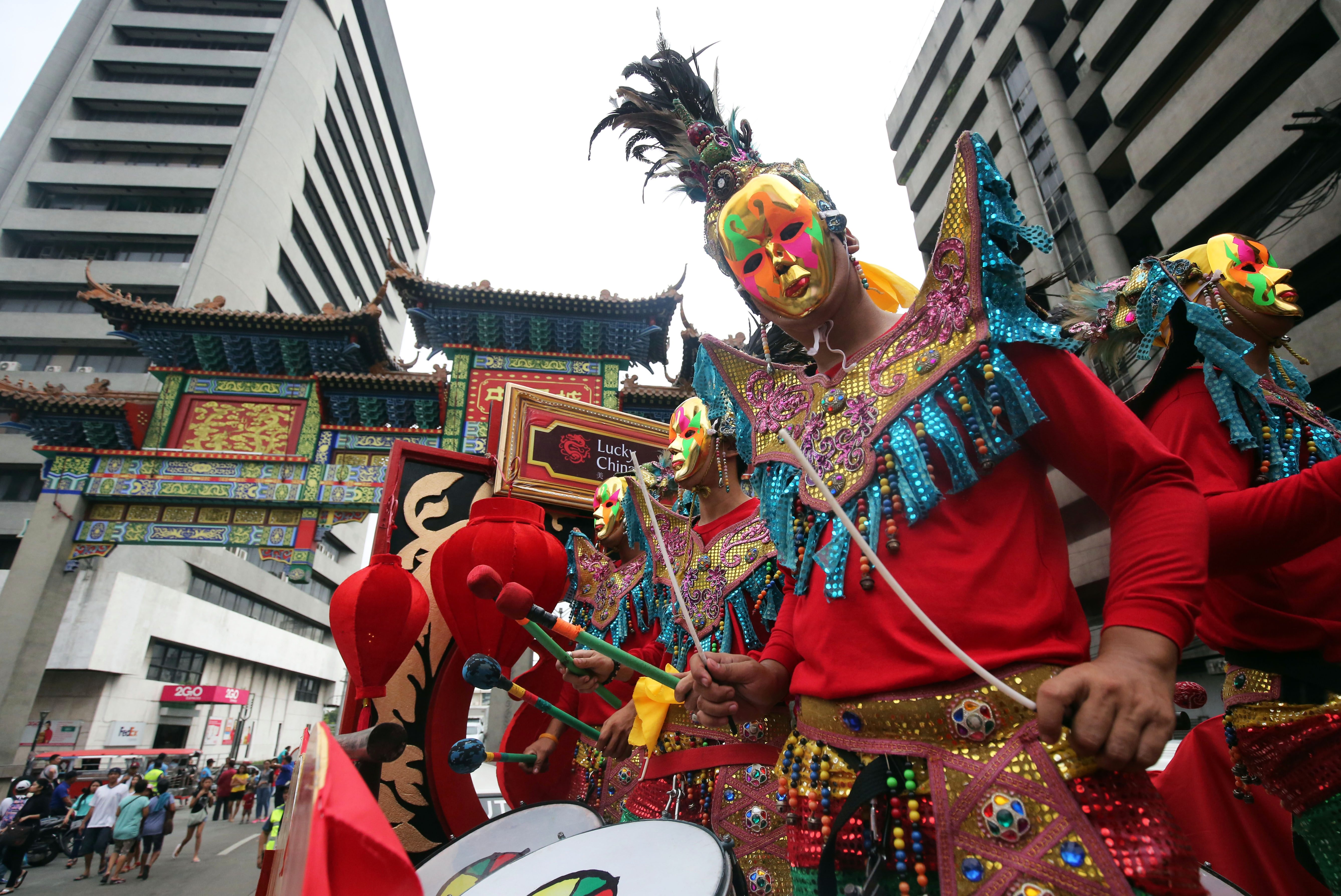 COLORFUL WELCOME. Masked men in colorful gear welcome revelers near the Filipino-Chinese Friendship Arch in Binondo. Photo by Ben Nabong/Rappler    