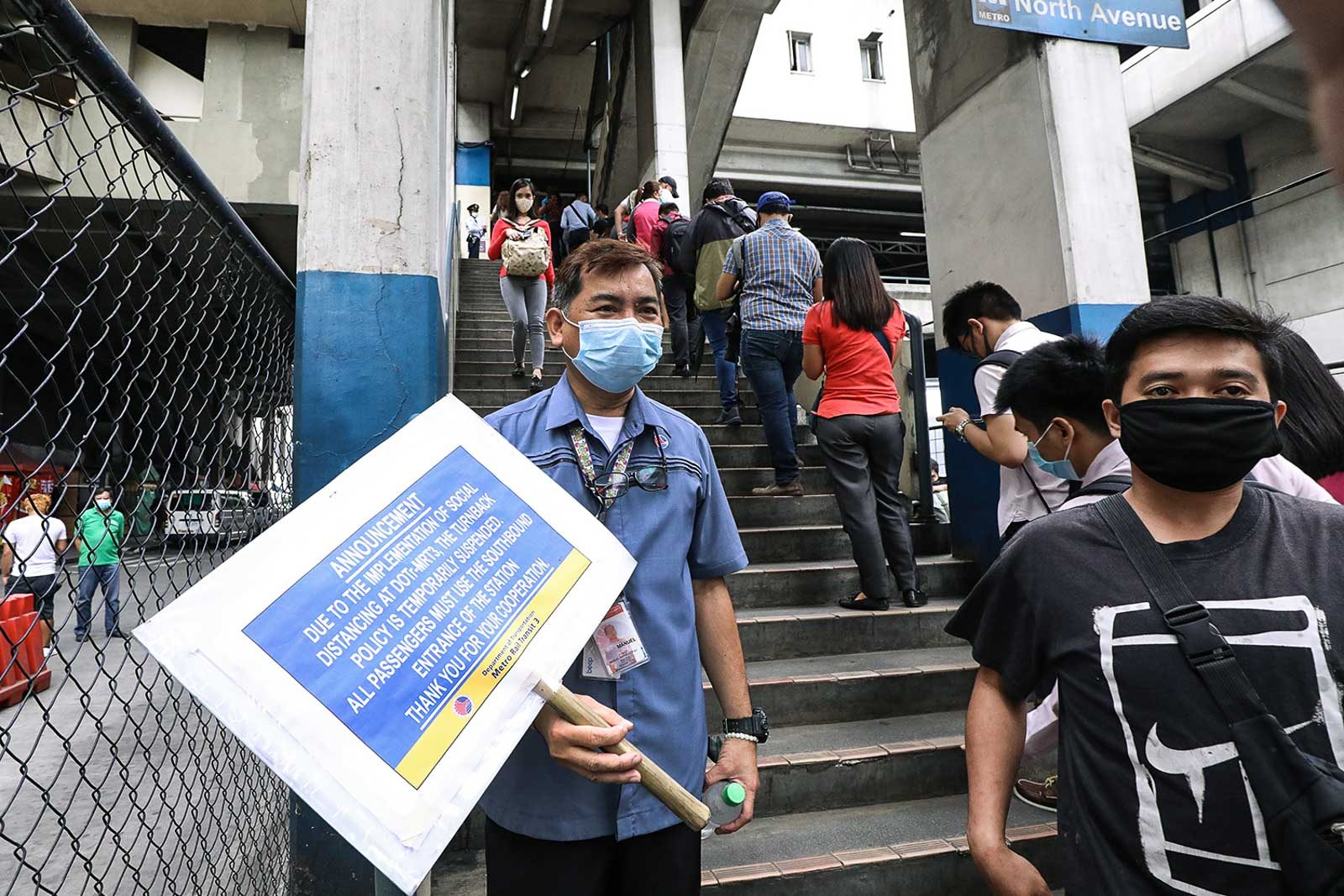 SOCIAL DISTANCING POLICY. An MRT-3 staff member holds up a sign reminding members about the social distancing policy to implemented in the train on March 16, 2020. Photo by Darren Langit/Rappler 