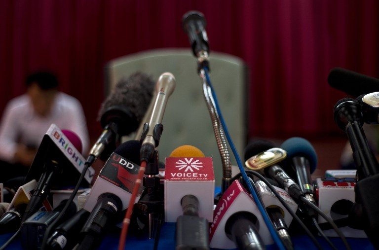 This picture taken on May 21, 2014 shows microphones of reporters working for TV stations sitting on a table ahead of a press conference at the Army club in Bangkok.  Manan Vatsyayana/AFP 