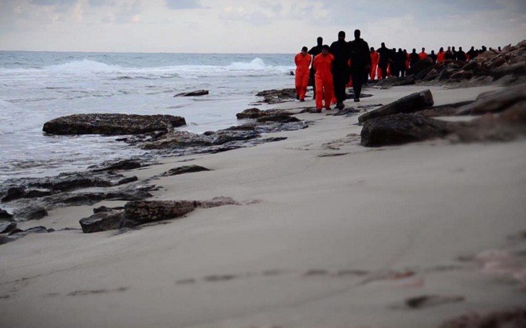 PERSECUTED CHRISTIANS. An image grab taken from a video released by the jihadist media arm Al-Hayat Media Centre on February 15, 2015, purportedly shows black-clad Islamic State fighters leading handcuffed hostages, said to be Egyptian Coptic Christians, wearing orange jumpsuits before their alleged decapitation on a seashore in Tripoli. Photo by Al-Hayat Media Centre/Handout/AFP   