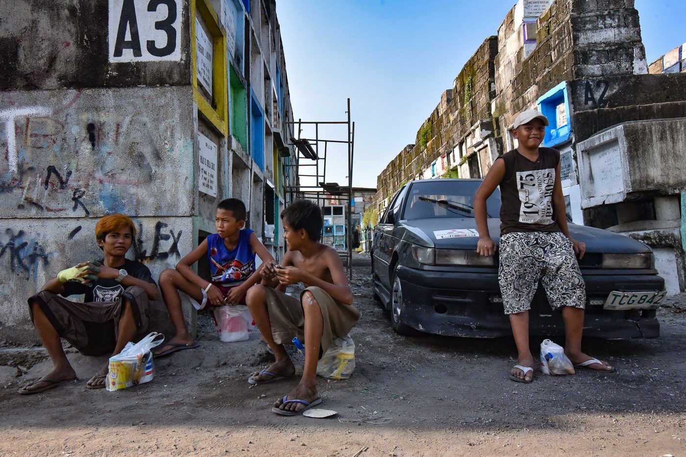 A group of teenagers wait for customers inside the Navotas Public Cemetery on October 27, 2017 
