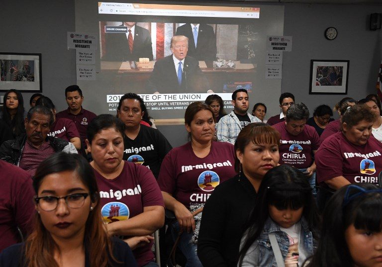 MIGRANT PROTEST. DACA recipients and their supporters turn their back on US President Donald Trump (on screen) as he talks about unity, during a State of the Union party at the Coalition for Humane Immigrant Rights and the California Dream Network offices in Los Angeles, California on January 30, 2018. Photo by Mark Ralston/AFP    