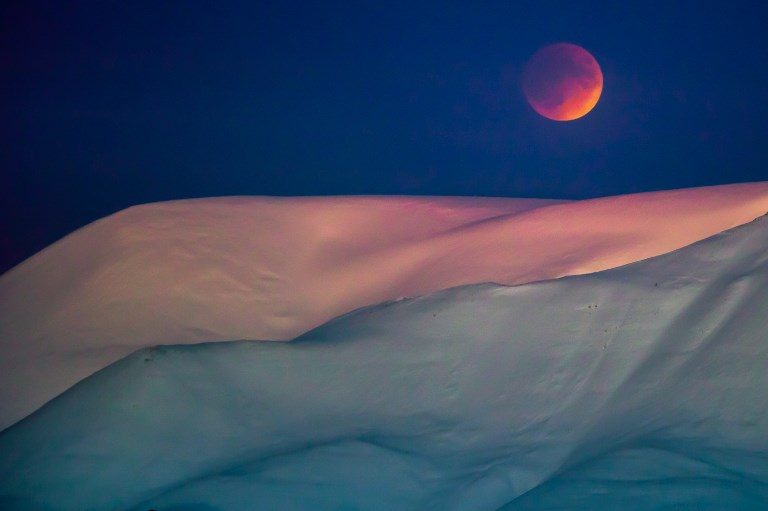 #SUPERBLUEBLOODMOON. The moon behind a mountain as seen from Longyearbyen, Svalbard, Norway on January 31, 2018. Photo by Heiko Junge/NTB Scanpix/AFP   