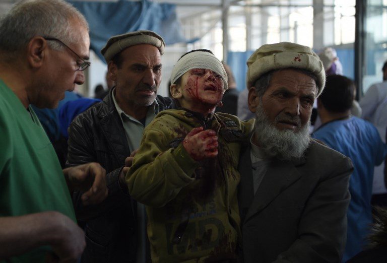 COLLATERAL VICTIM. An Afghan man holds a wounded child at the Jamhuriat Hospital after a car bomb explosion near the old Interior Ministry building in Kabul on January 27, 2018. Photo by Wakil Kohsar/AFP  