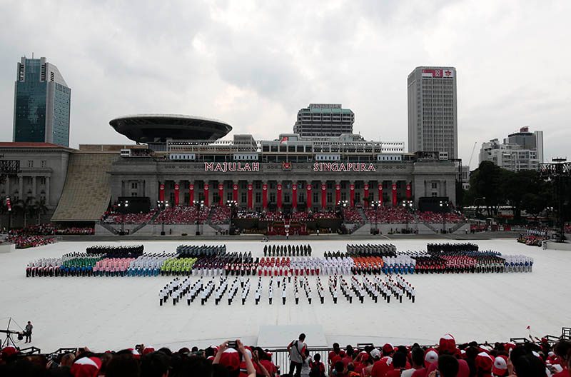 Military and civilian contingents formed up on the parade square, called the 'Padang,' during the National Day Parade in Singapore. The parade features a military column, and an aerial flypast titled 'Salute to the Nation.' Photo by Wallace Woon/EPA  