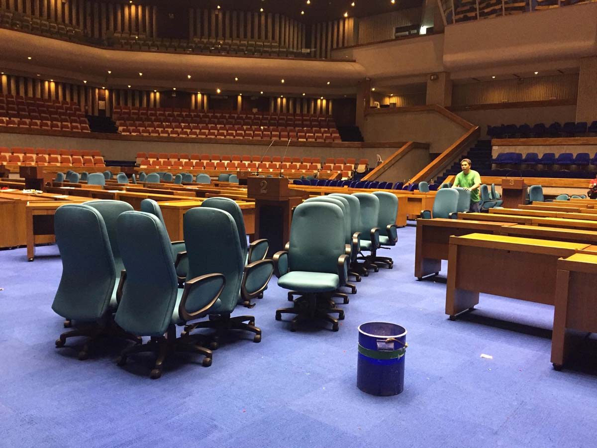 REARRANGING. A man rearranges the chairs and tables usually used by lawmakers during the cleaning preparations at the Batasang Pambansa. Photo by Mara Cepeda/Rappler  