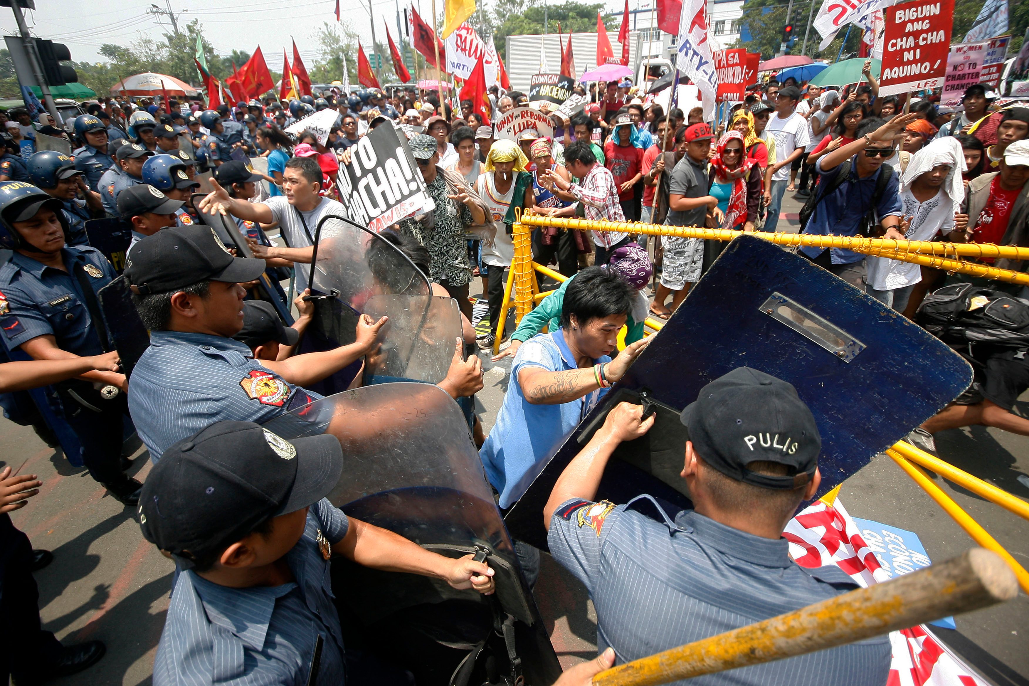 PROTESTS. Militant farmers clash with the anti-riot police as they gathered at the gates of the House of Representatives in Quezon City on Wednesday, June 10, to denounce proposed amendments to the economic provisions of the Constitution. Photo by Ben Nabong/Rappler 
