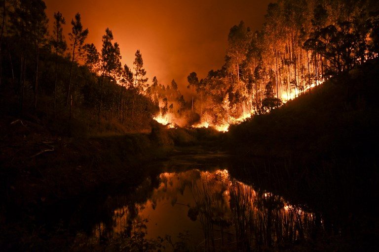 FOREST ABLAZE. A wildfire is reflected on a stream at Penela, Coimbra, central Portugal, on June 18, 2017. Photo by Patricia de Melo Moreira/AFP   