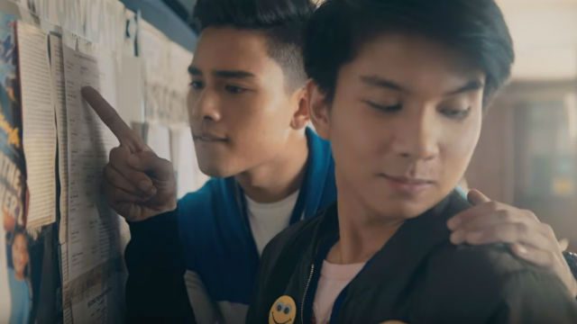KILIG. JR looks at the hand of Vincent (Marco Gumabao), who is looking at the billboard announcement. 