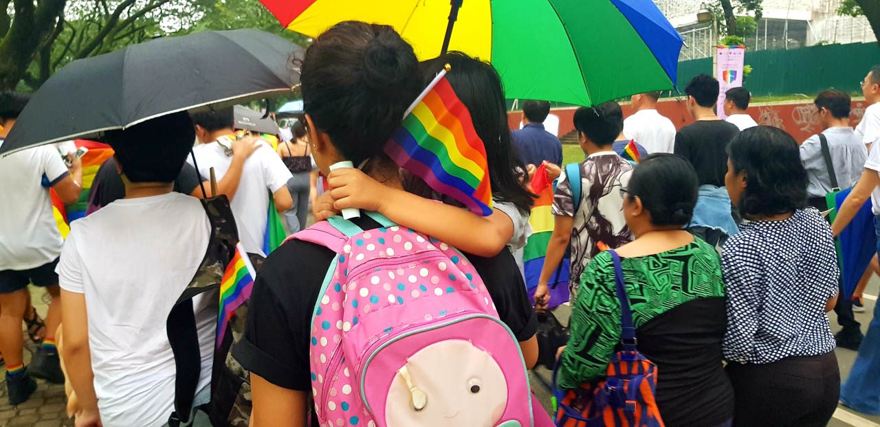 STARTING 'EM YOUNG. A UP Diliman faculty member carries her daughter as she marched in solidarity with the LGBTQ+ community . Photo by Jaia Yap/Rappler  