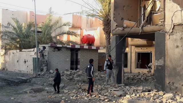 Fallujah residents inspect a house damaged in an apparent airstrike carried out by the Iraqi army on Fallujah, Iraq, 10 March 2015. Stringer/EPA 