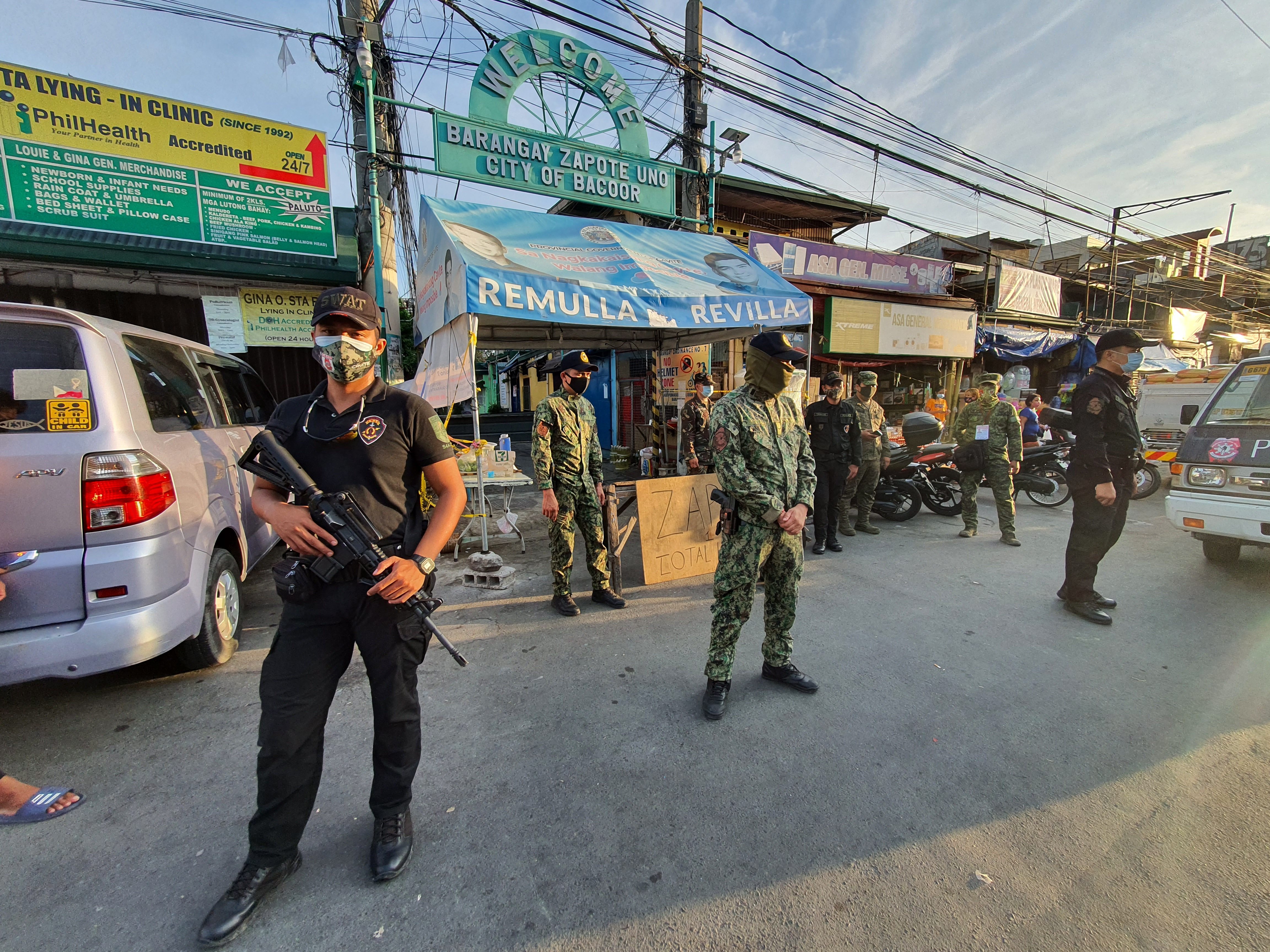 LOCKDOWN. Members of the Bacoor Philippine National Police and the Philippine Army stand guard at Zapote 1 village which is under lockdown until July 24, 2020 due to rising cases of COVID 19 in the area. Photo by Dennis Abrina/Rappler 