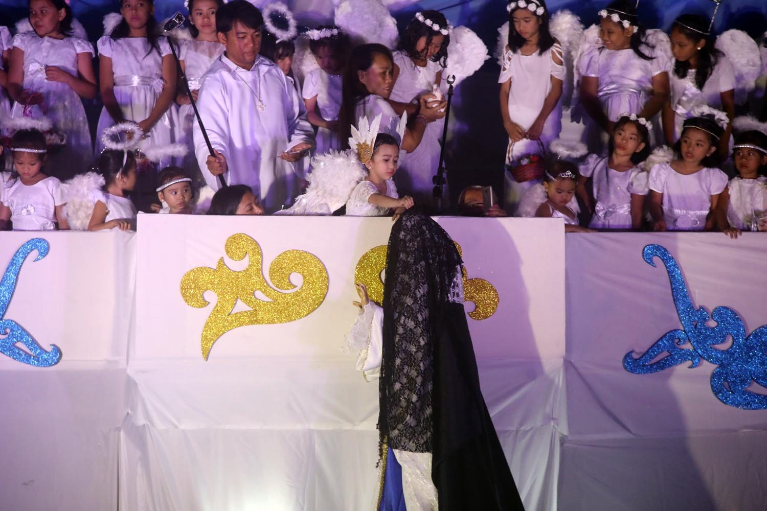 A child dressed as an angel removes the veil of the Blessed Virgin Mary during the Easter Salubong at Saint Peter Parish in Quezon City on April 1, 2018. Photo by Darren Langit/Rappler 