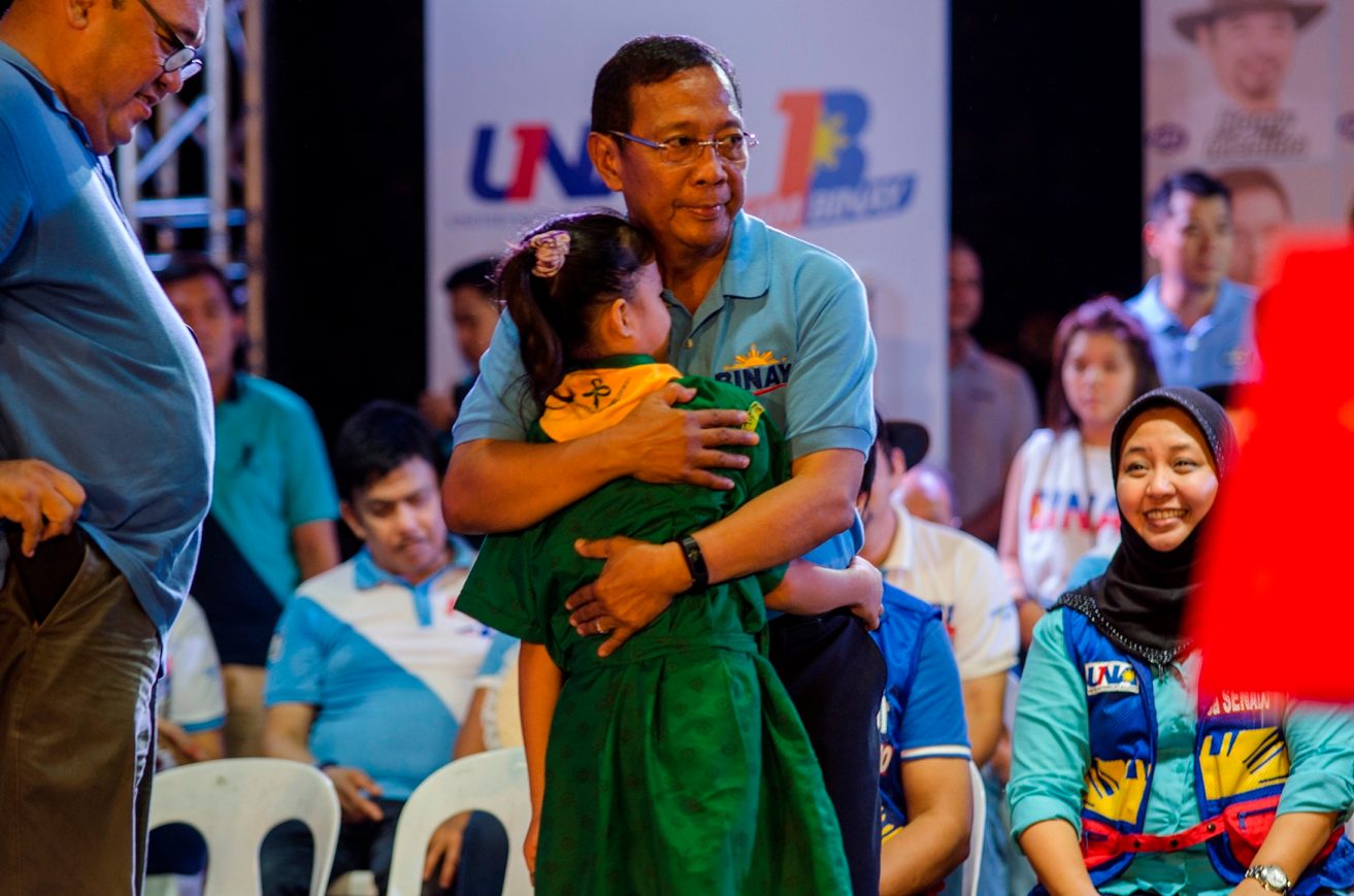 ONSTAGE EMBRACE. Binay hugs little girl scout Susan Ebon, who delivered a poem titled "Binay" during the miting de avance. 
