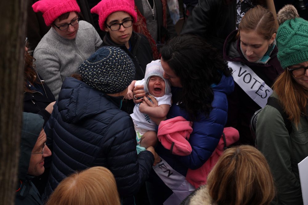 A baby hold a mini-protest amidst the Women's March on Washington.  