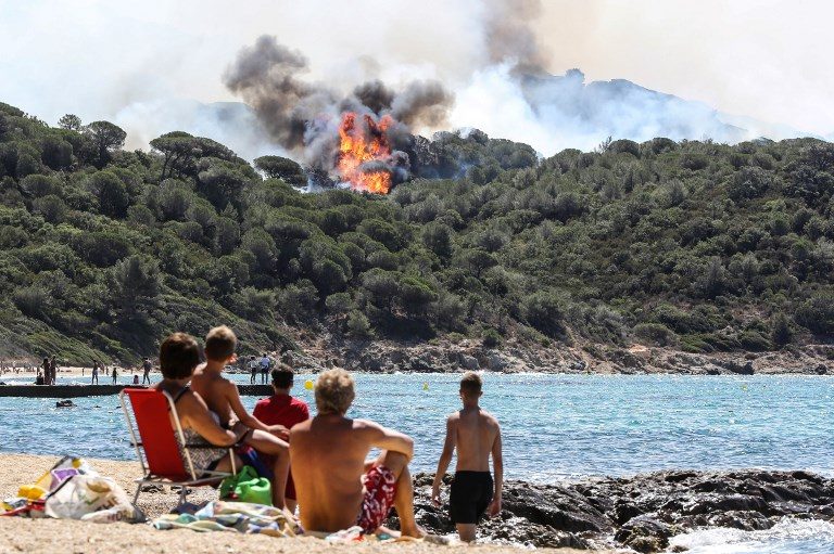 INFERNO. People enjoy the beach as they look at a forest fire in La Croix-Valmer, near Saint-Tropez, France on July 25, 2017. Photo by Valery Hache/AFP   
