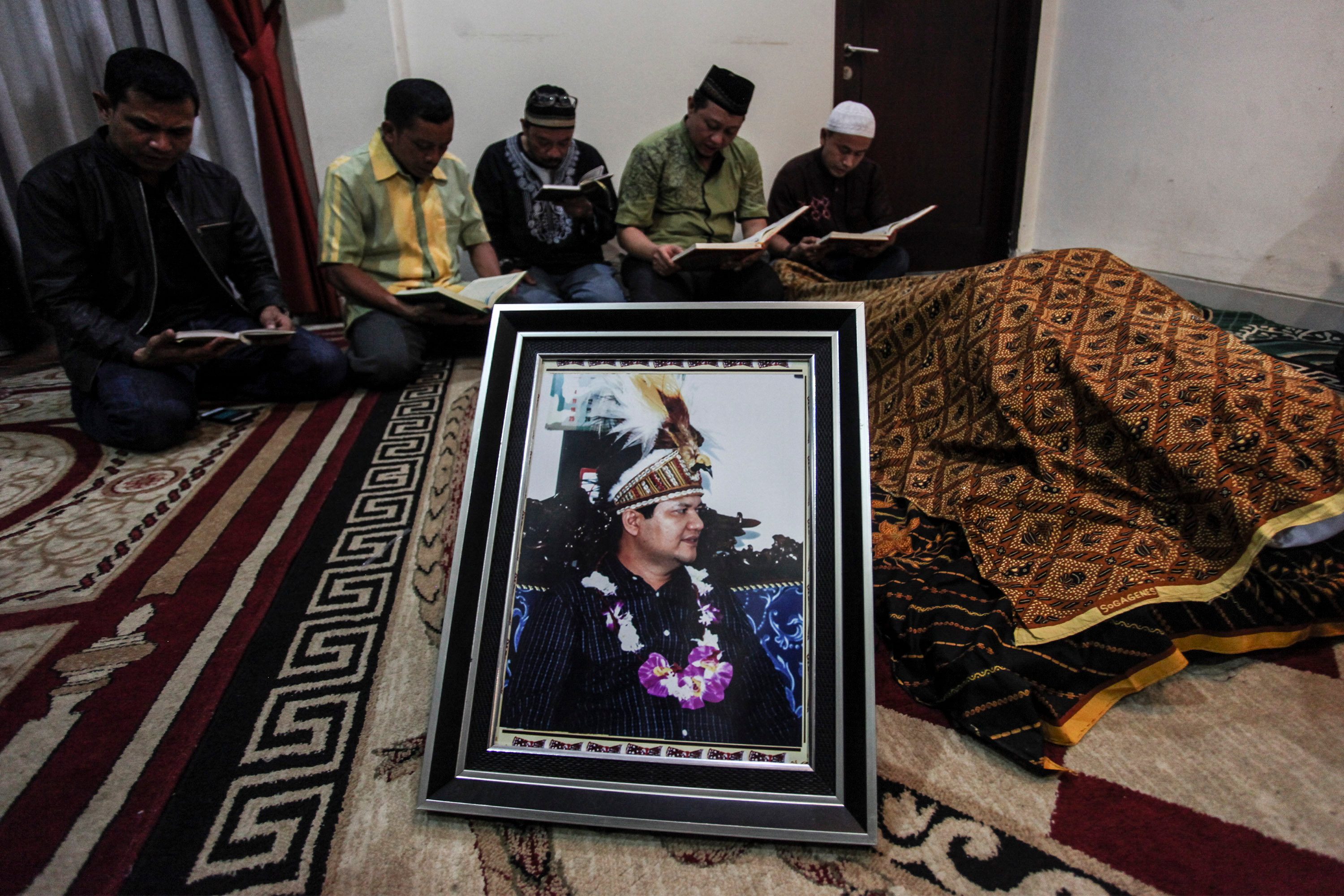 Kerabat membacakan Al-Qur’an di depan jenazah Ketua KPU Husni Kamil Manik pada 7 Juli 2016. Foto oleh Muhammad Adimaja/Antara 