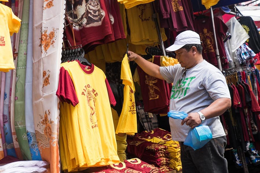 WHAT TO BUY. A man looks at a T-shirt that bears the image of the Black Nazarene. 