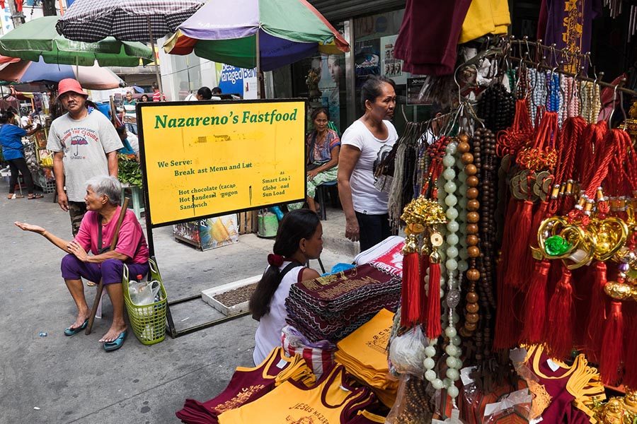 FAITH AND BUSINESS. Chinese good luck charms, together with Nazareno T-shirts and towels are sold near Nazareno's Fastfood where a lot of devotees eat. 