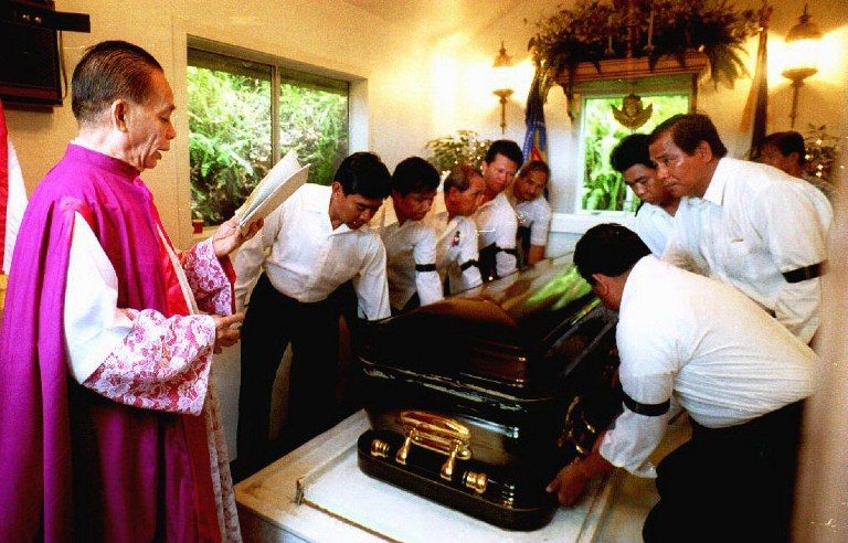 TRANSFER TO PH. Monsignor Domingo Nebres (L) reads his benediction in Hawaii as the body of the late Philippine President Ferdinand Marcos is removed from the mausoleum where he laid in state since dying in exile in 1989. Photo by George Lee/AFP 