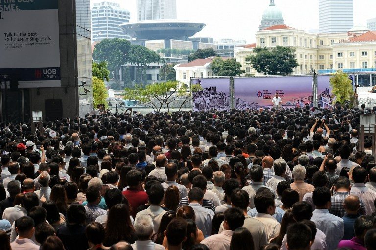 CROWD DRAWER. This photograph taken on September 8, 2015 shows Supporters and office workers listen to gather to listen to Singapore's Prime Minister Lee Hsien Loong (background on stage), from the ruling People's Action Party, as he gives a speech to a lunch time crowd at a rally in the financial district of Raffles Place ahead of Singapore's September 11 election. Roslan Rahman/AFP 