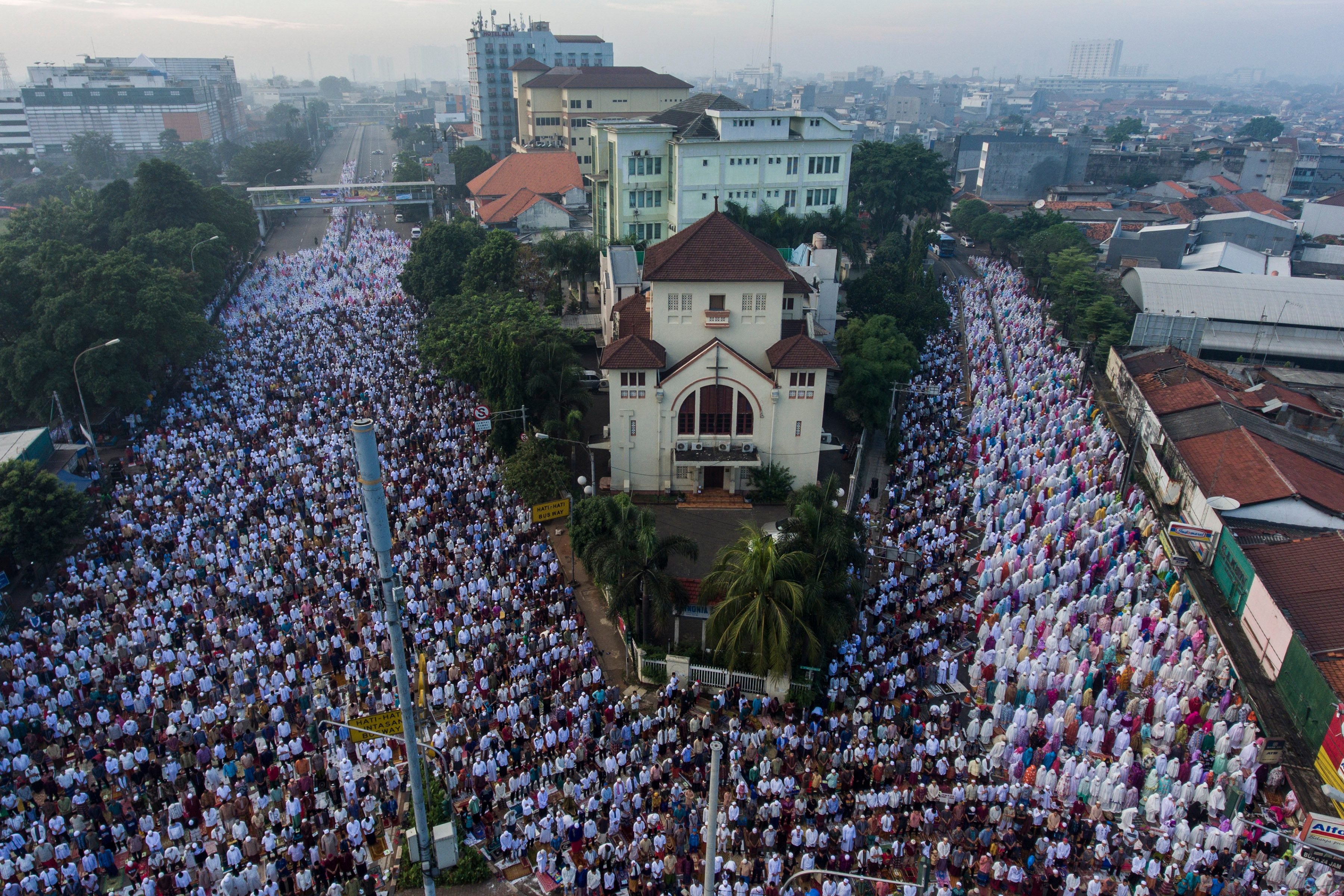 RIBUAN UMAT MUSLIM SALAT. Foto aerial ribuan umat muslim mengikuti salat Idul Fitri 1438 H di Jatinegara, Jakarta Timur, Minggu, 25 Juni. Foto oleh Sigid Kurniawan/ANTARA 