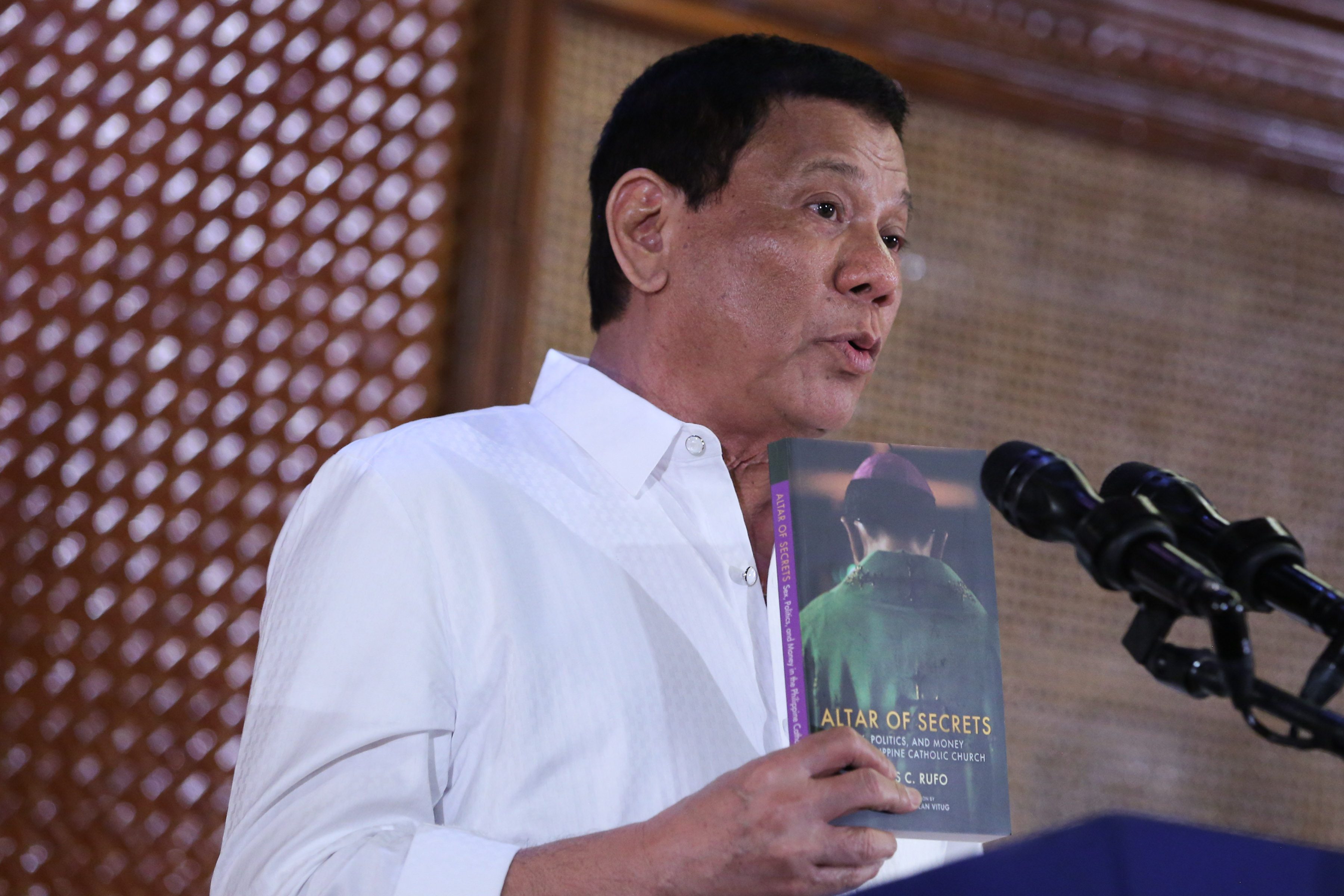 DUTERTE VS CHURCH. President Rodrigo Duterte shows a book about corruption in the Catholic Church during a speech on January 24, 2017. File photo by King Rodriguez/Presidential Photo 
