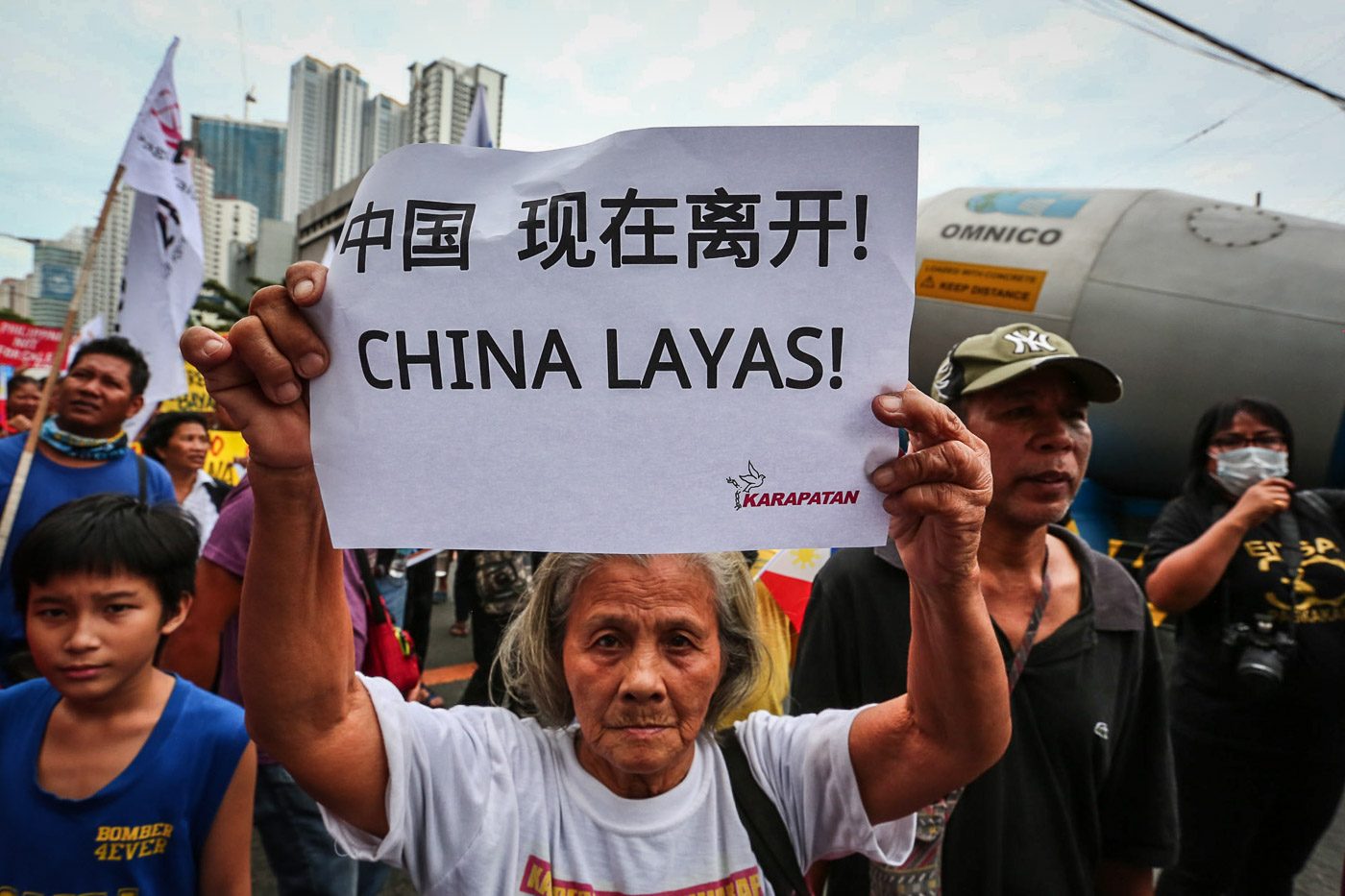STRONG STAND. A woman carries a sign with the words "China layas!" during a protest at the Chinese Consulate in light of Xi Jinping's state visit to the Philippines. Photo by Jire Carreon/Rappler 