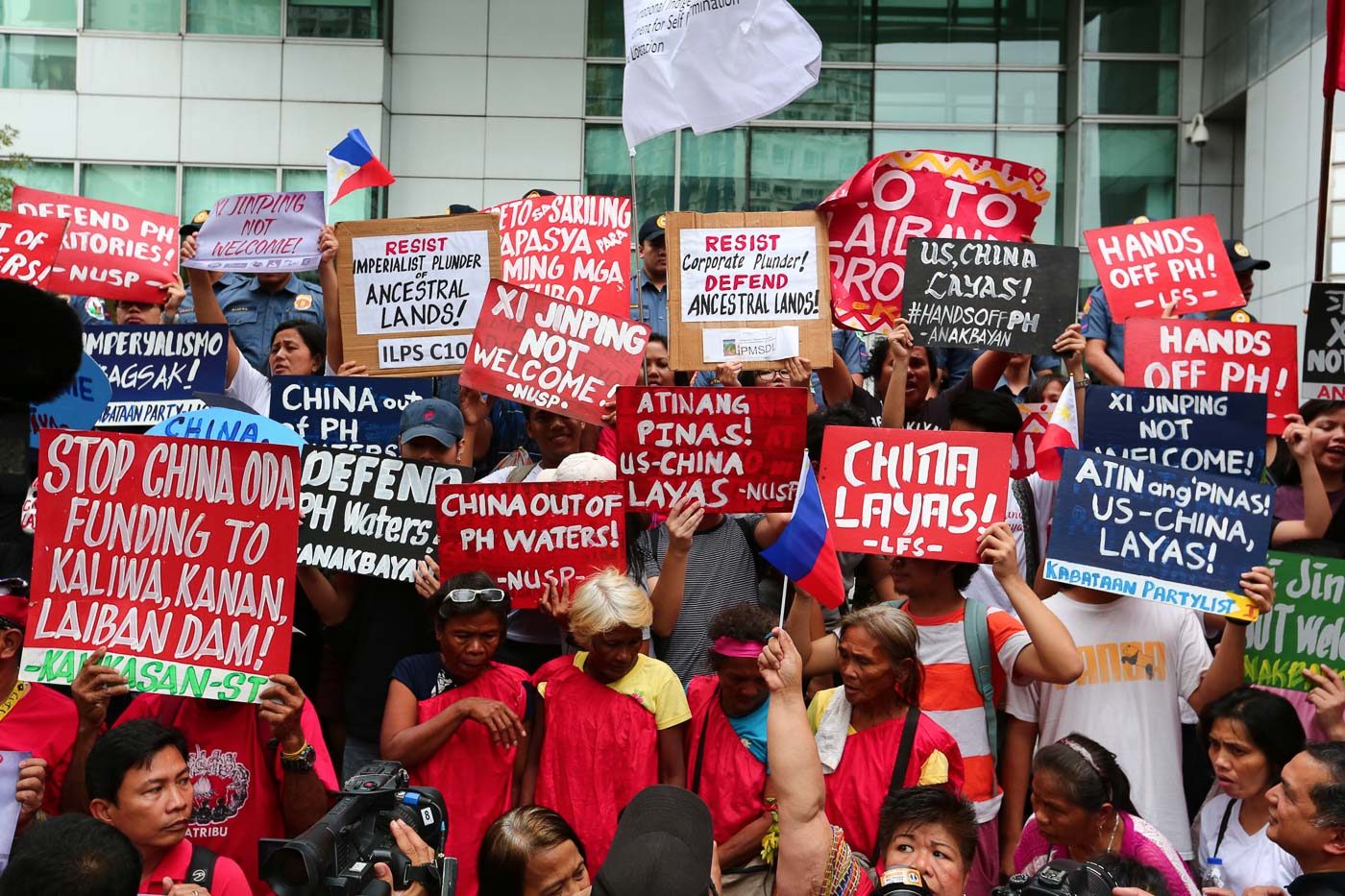 STRONG STATEMENTS. People carry signs to show their strong objection to possible deals and plans with China during the protest at the Chinese Consulate on the day of Xi Jinping's arrival in the Philippines. Photo by Jire Carreon/Rappler 