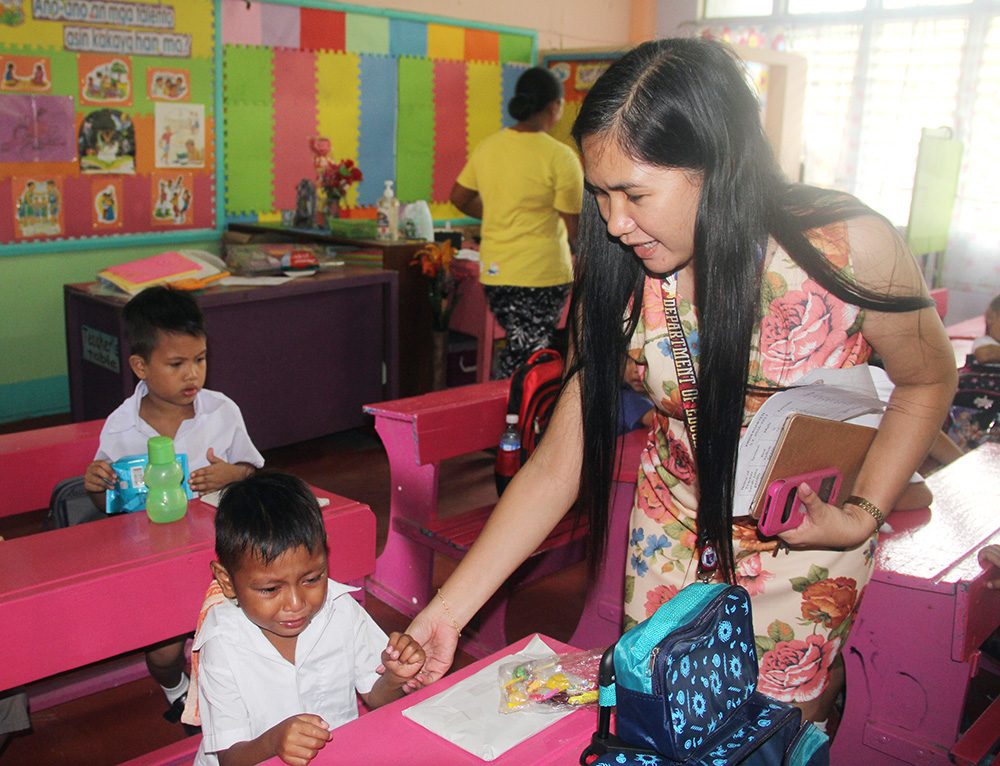 COMFORT. Teacher Lara tries to comfort a boy crying on the first day of school. Photo by Rhaydz Barcia/ Rappler 