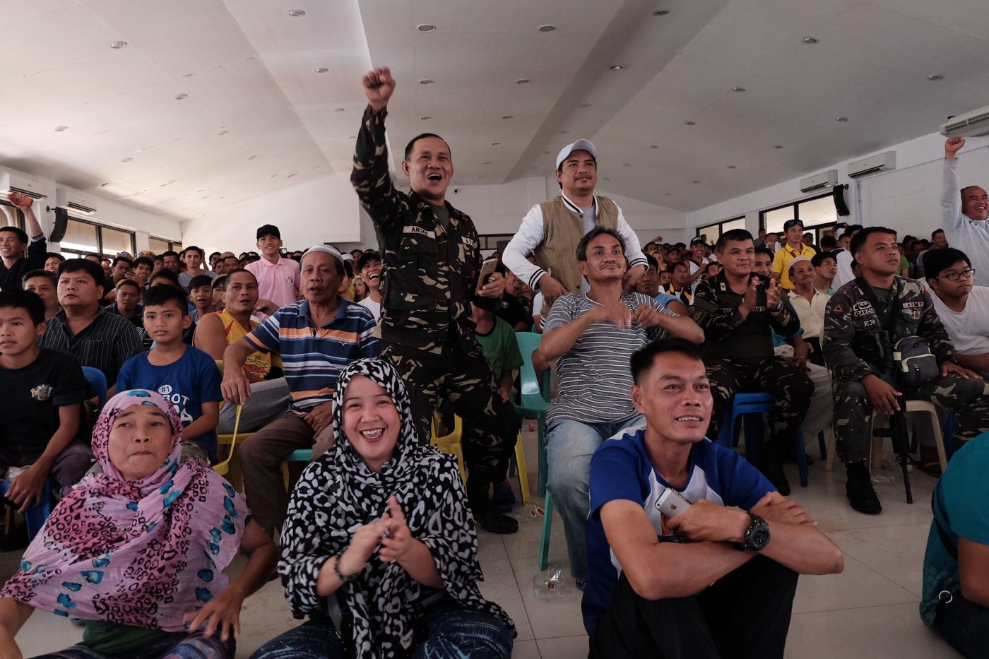 RESPITE. Residents of Marawi City and soldiers react each time Manny Pacquiao lands a punch on Jeff Horn as they watch the fight in the Lanao del Sur provincial capitol in Marawi City on July 2, 2017. Photo by Bobby Lagsa/Rappler   