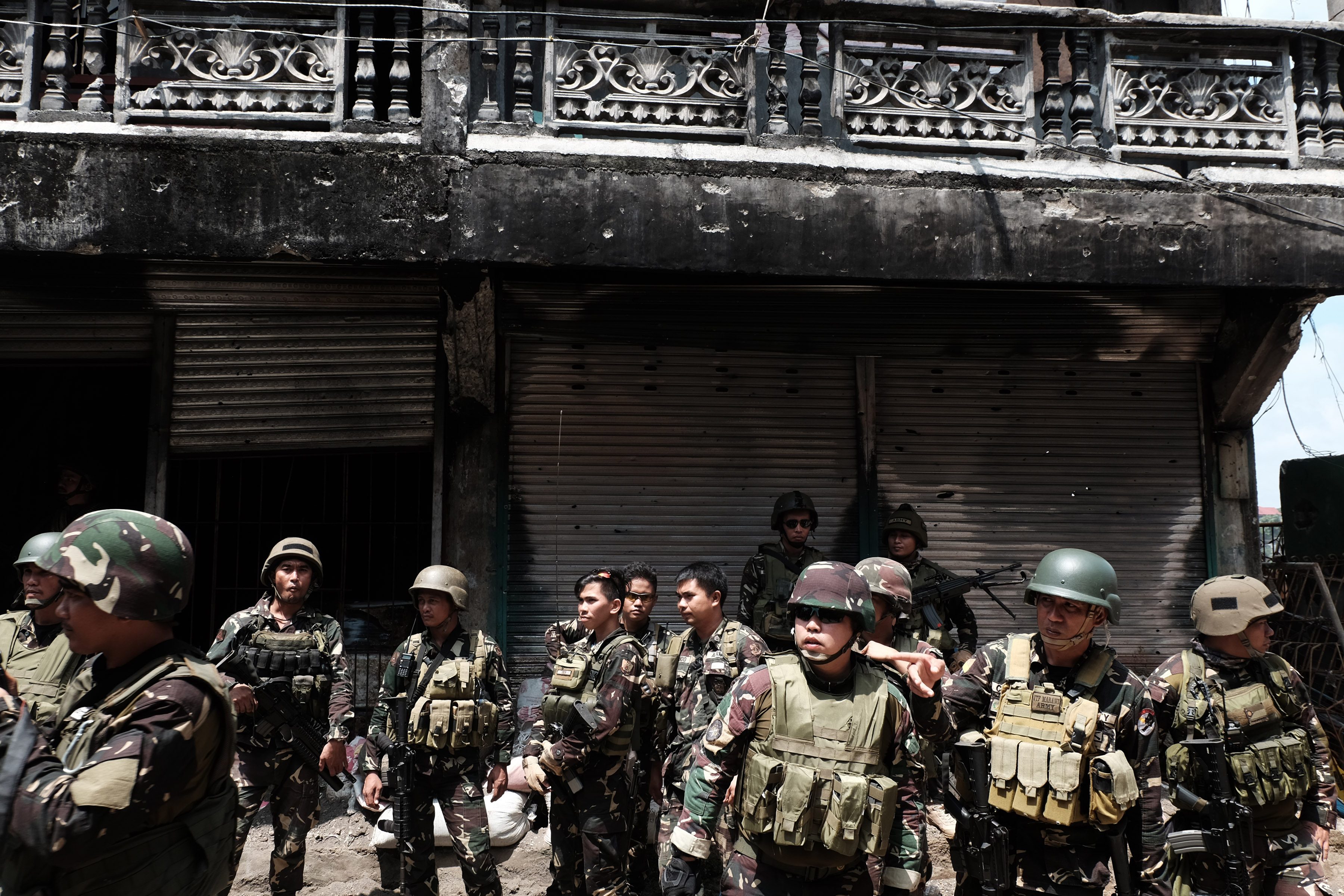 Soldiers stand outside a cleared building near Mapandi bridge. Photo by Bobby Lagsa/Rappler 