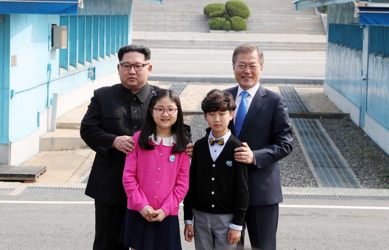 TOGETHER. North Korea's leader Kim Jong-Un (L) and South Korea's President Moon Jae-in (R) pose with children after meeting at the Military Demarcation Line that divides their countries ahead of their summit at Panmunjeom on April 27, 2018. AFP PHOTO / Korea Summit Press Pool  