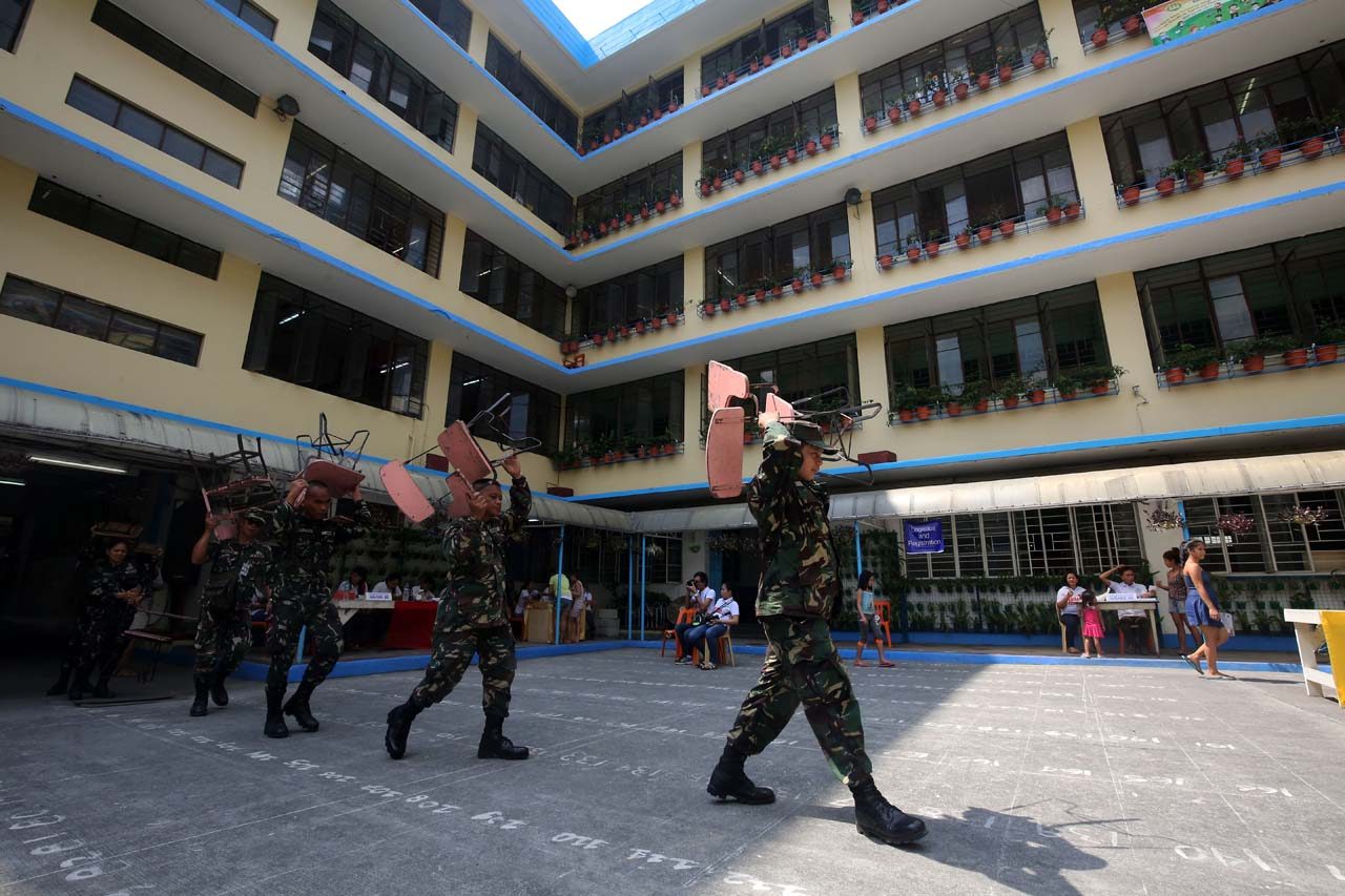 Members of the Armed Forces of the Philippines help students in carrying arm chairs during the Brigada Eskwela at the Rosario Almario Elementary School in Tondo, Manila on May 15, 2017. Photo by Ben Nabong/Rappler 