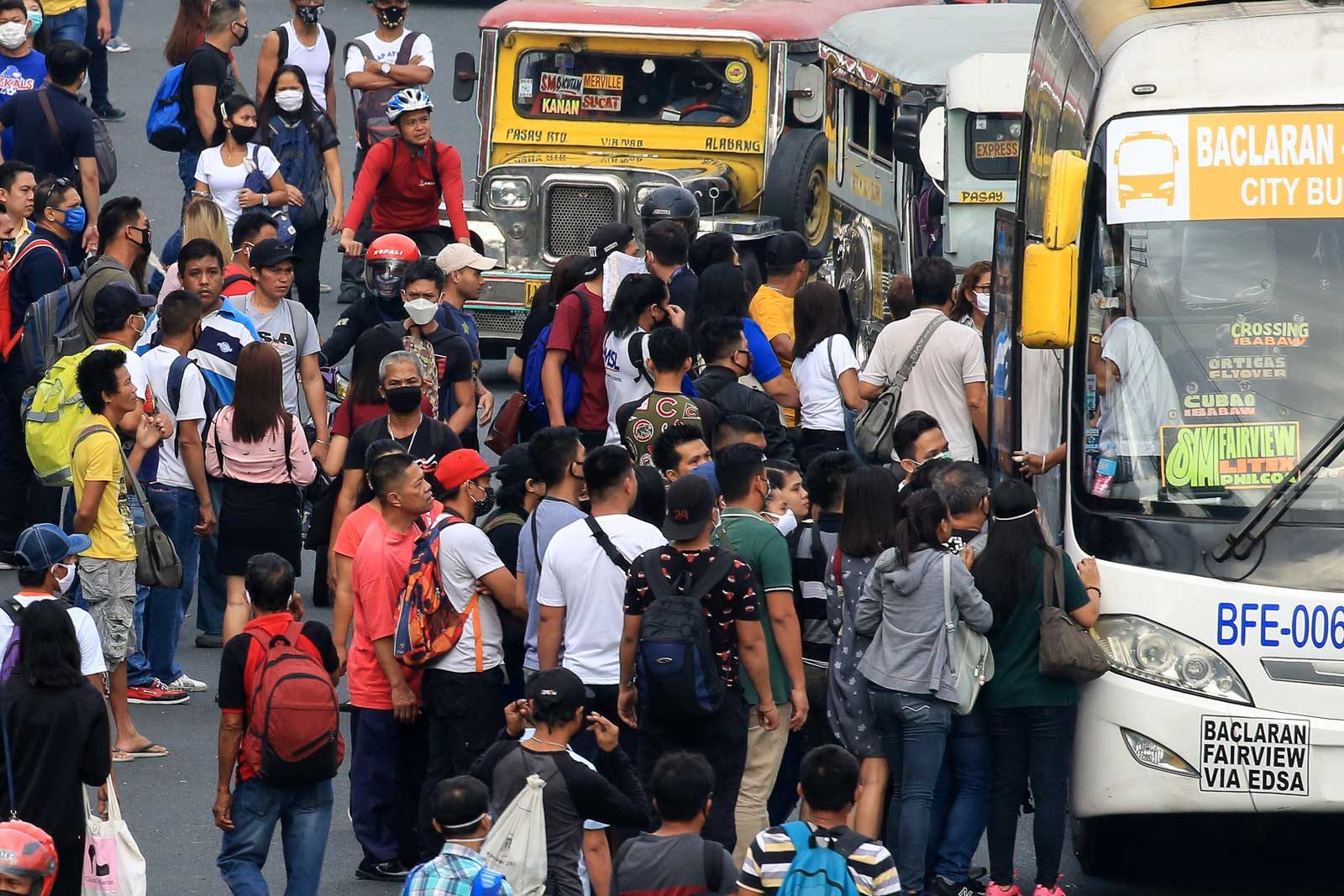 WAITING IN LINE. Commuters stand shoulder to shoulder while waiting to ride a bus in Pasay City. Photo by Ben Nabong/Rappler  