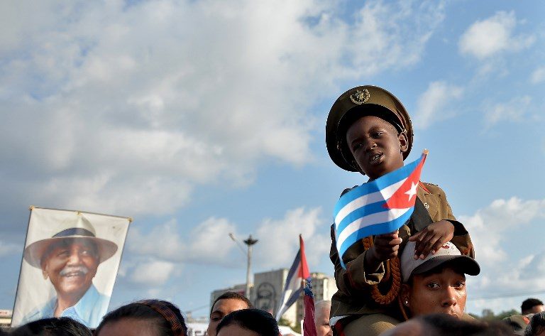 HOPE. A boy holds a Cuban national flag during the May Day rally at Revolution Square in Havana on May 1. Photo by Yamil Lage/AFP  