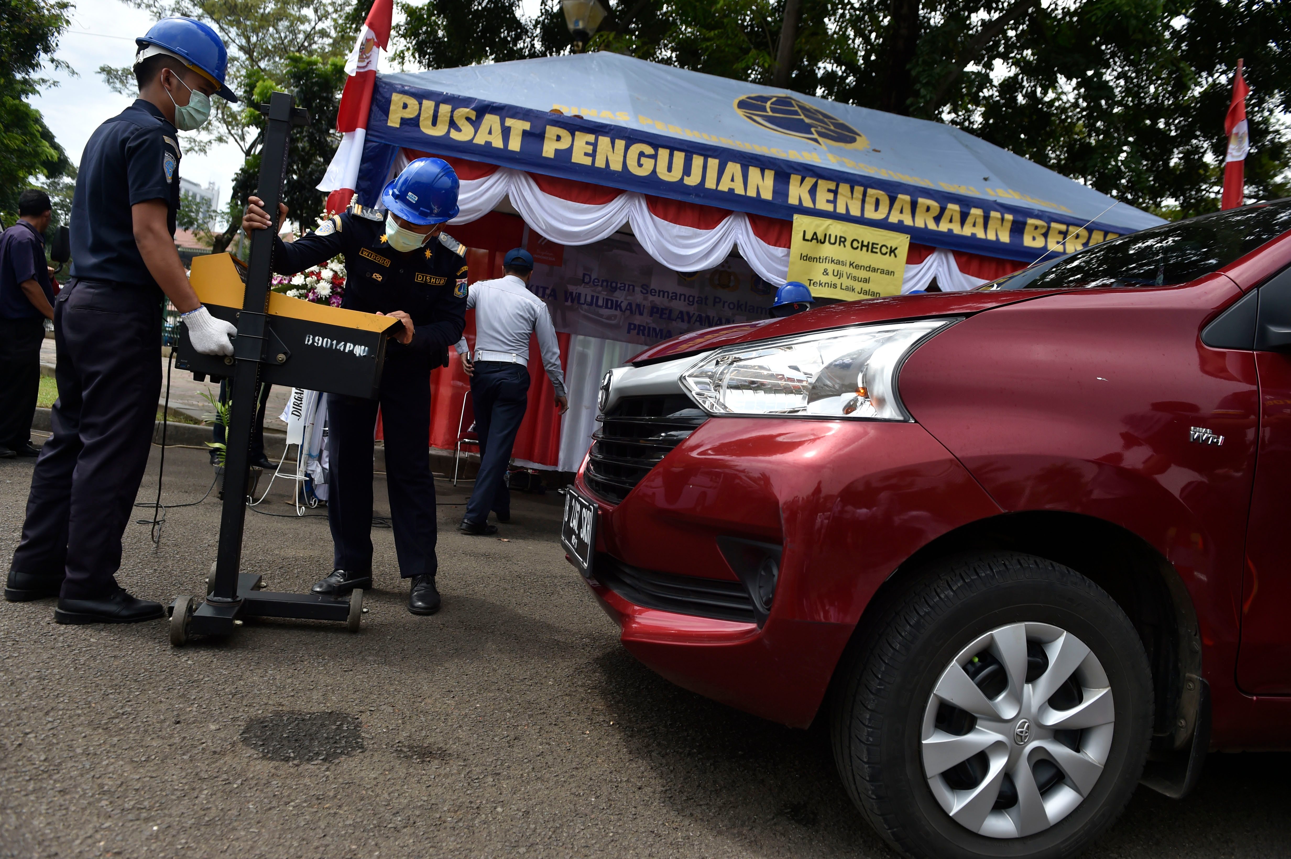 Petugas melakukan pengecekan kendaraan saat berlangsung layanan uji SIM A Umum dan Ujian Berkala (KIR) angkutan umum berbasis online serta taksi umum di Silang Monas, Jakarta, pada 15 Agustus 2016. Foto oleh Puspa Perwitasari/Antara 