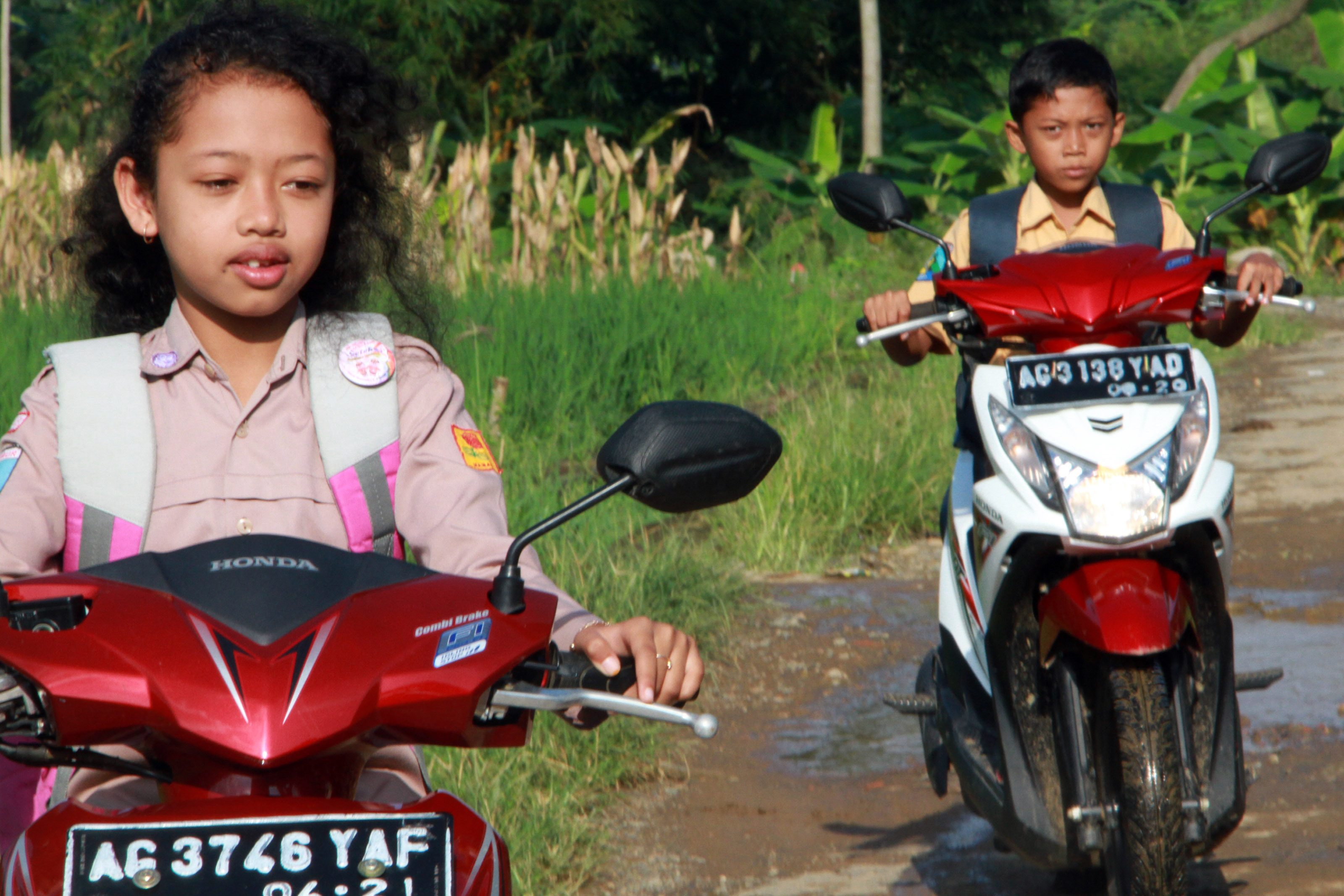 Dua pelajar SD mengendarai sepeda motor ke sekolahnya di SD Negeri 1 Bendoroto, Munjungan, Trenggalek, Jawa Timur, pada 23 Juli 2016. Foto oleh Destyan Sujarwoko/Antara 