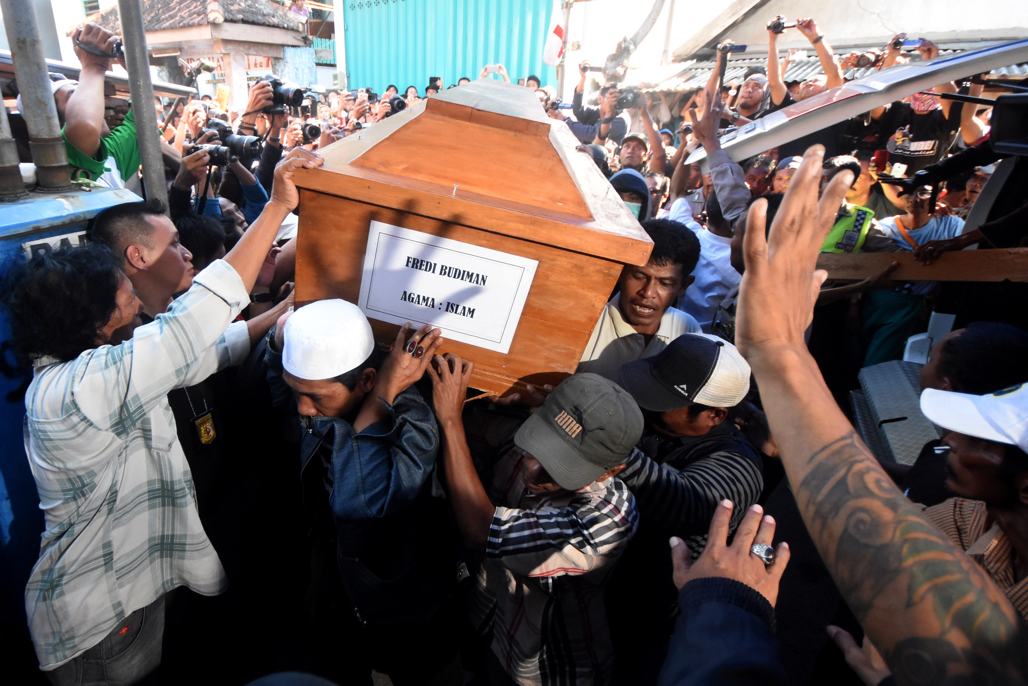 Warga mengangkat peti jenazah terpidana mati kasus narkoba, Freddy Budiman, ketika tiba di Surabaya, Jawa Timur, pada 29 Juli 2016. Foto oleh M Risyal Hidayat/Antara 