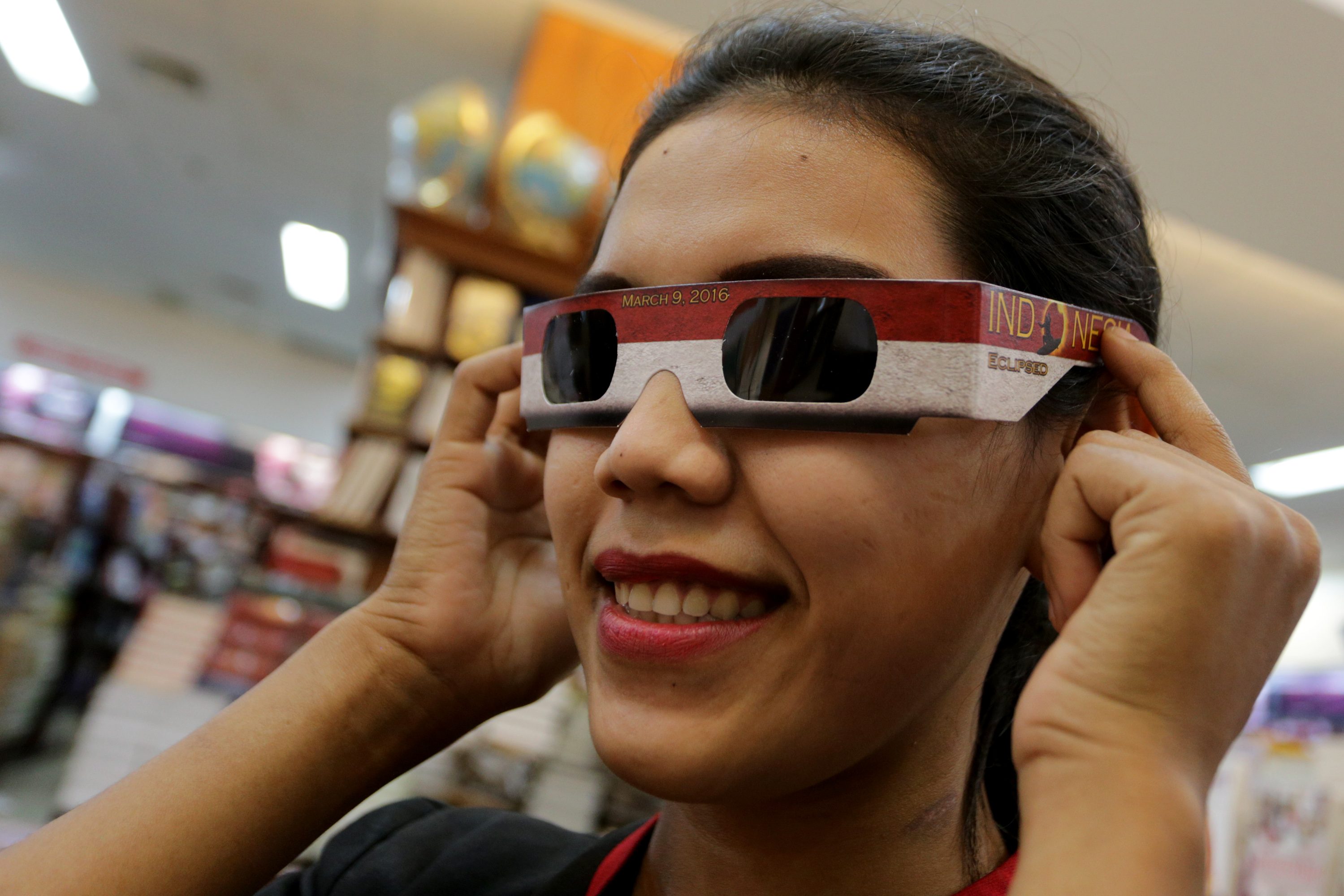 Warga mencoba kacamata gerhana matahari di salah satu toko buku di Palembang, Sumatra Selatan, Sabtu, 5 Maret. Foto oleh Nova Wahyudi/ANTARA 