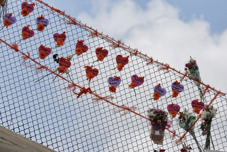 TRIBUTE. Memorials are seen on a fence surrounding Marjory Stoneman Douglas High School in Parkland, Florida, on February 21, 2018. Photo by Rhona Wise/AFP  