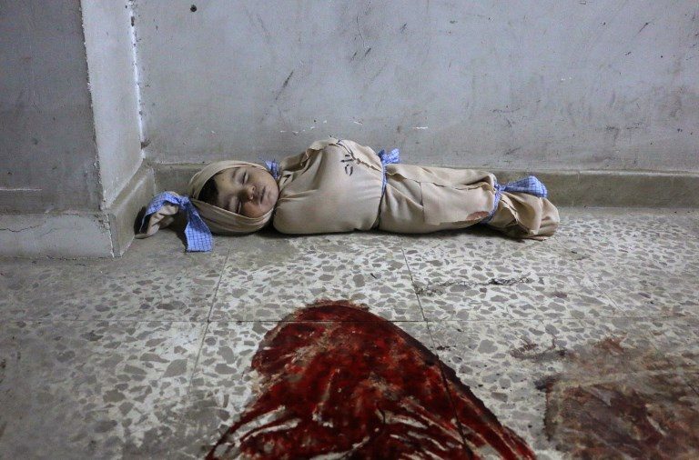 COLLATERAL VICTIM. The body of a Syrian baby lies wrapped in a shroud on the floor of a makeshift clinic following Syrian government bombardments in Douma, in the besieged Eastern Ghouta region on the outskirts of the capital Damascus on February 22, 2018. Photo by Hamza Al-Ajweh/AFP 