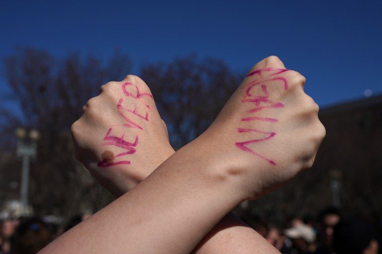 'NEVER AGAIN'. A student displays a message written on the back of her hands as hundreds of high school and middle school students from the the DC area, Maryland, and Virginia staged walkouts and gather in front of the White House in support of gun control in the wake of the Florida shooting February 21, 2018, in Washington, DC. Photo by Mangel Ngan/AFP  