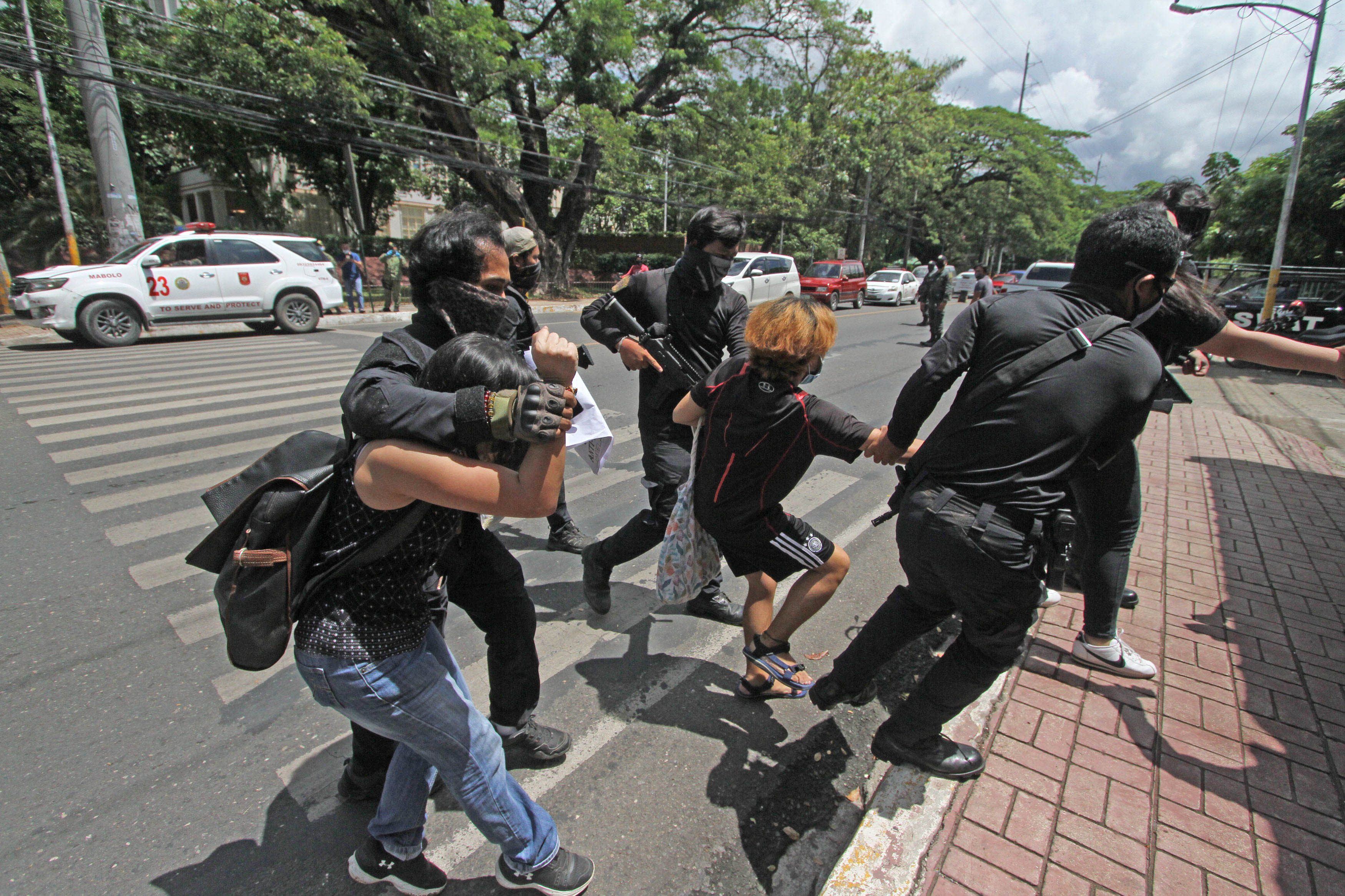 ARRESTED. Police drag two activists who joined an anti-terrorism bill protest in front of the gfate of University of the Philippines Cebu campus on June 5, 2020. Police say they violated the rule on mass gathering as Cebu City is under general community quarantine Photo by Gelo Litonjua/Rappler