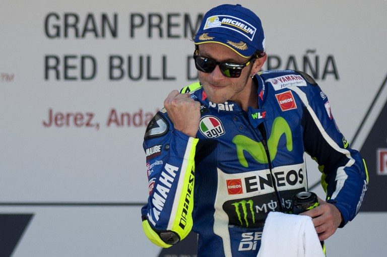 MENANG. Pembalap asal Italia Valentino Rossi merayakan kemenangannya di podium, setelah 10 balapan tanpa juara. Foto oleh Jorge Guerrero/AFP 